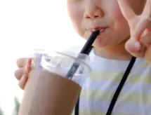 ストローで飲み物を飲むお子さま